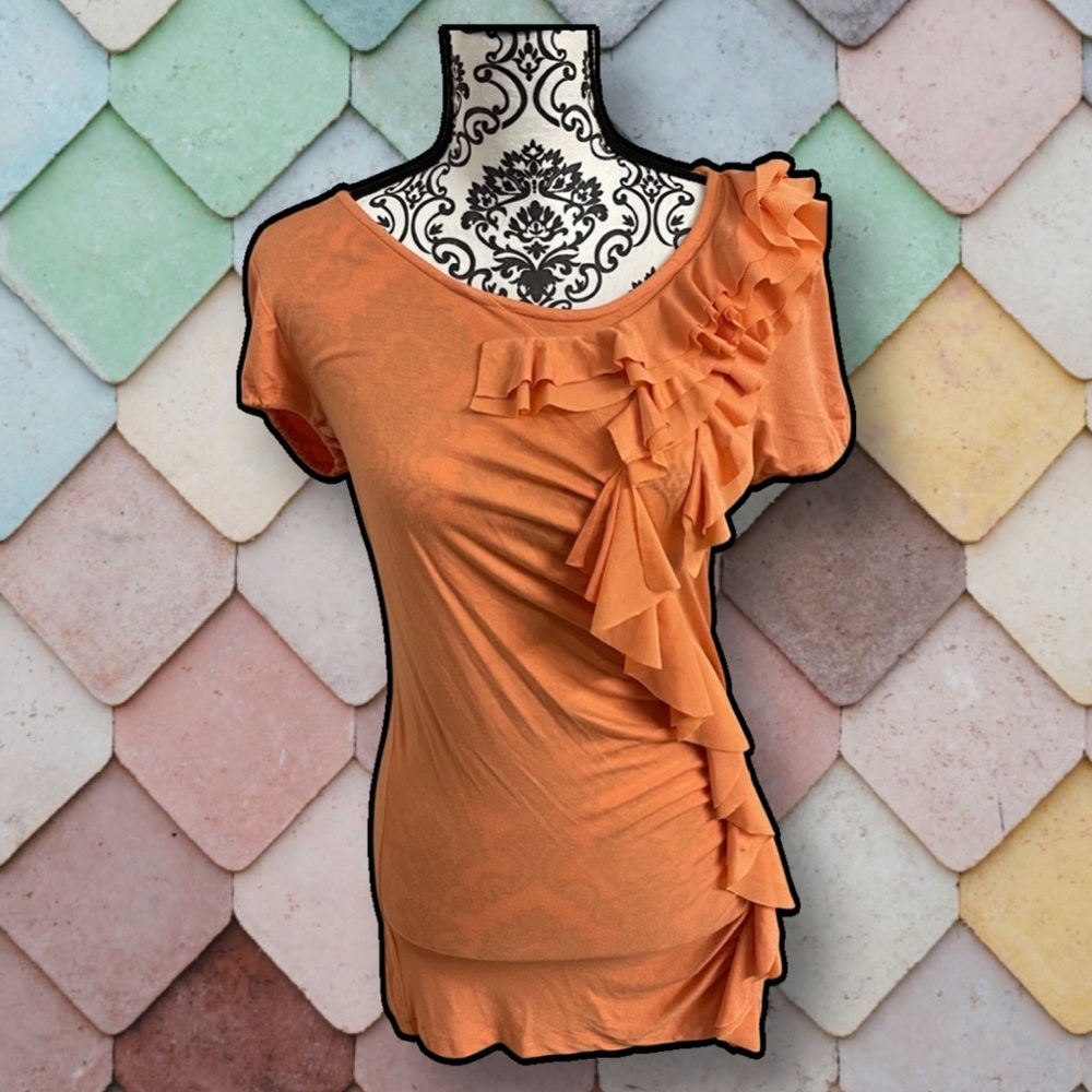 Isabella Rodriguez T-shirt orange with ruffle down the front.